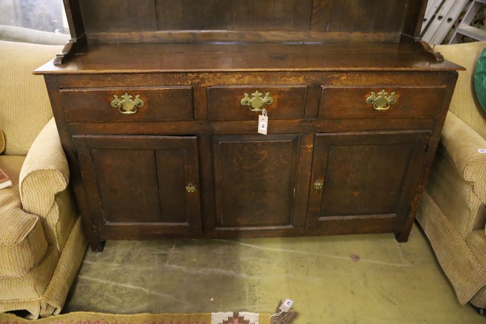 A mid-18th century oak dresser having later boarded plate rack over short drawers and panelled doors, width 151cm, depth 43cm, height 2